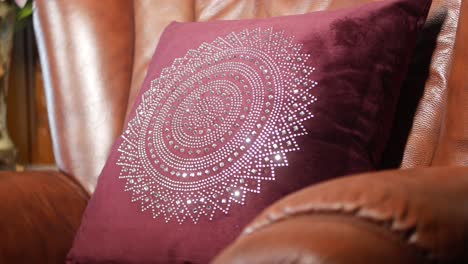 almohada de terciopelo marrón adornada en una silla de cuero