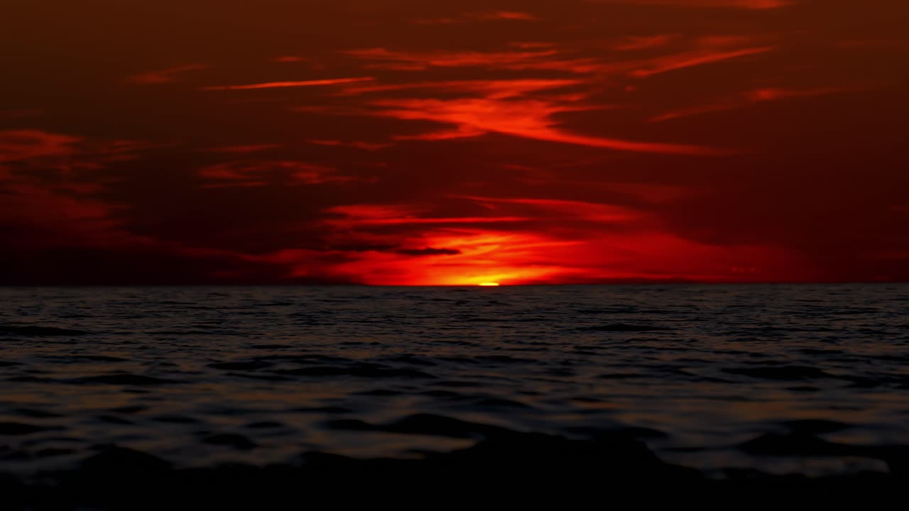 Peaceful Adriatic sunset evening at Istria beach with sun sinking into the sea, red sky and waves