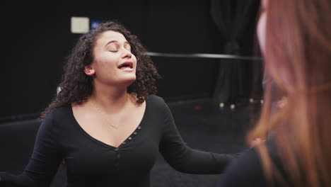 teacher with drama students at performing arts school in studio improvisation class