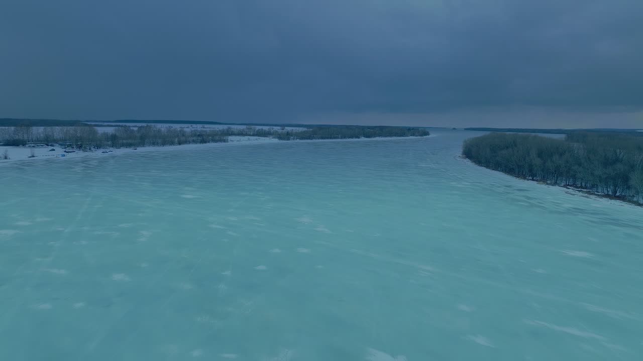 얼어붙은 강,  얼음 위를 날아가는 드 터, 넓은 강, 얼어붙는 겨울의 날, 얼어 붙은 강 주변에는 숲이 있습니다.