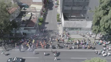 Crowds-of-diverse-people-in-carnival-costumes-marching-through-streets-of-Mexico-City