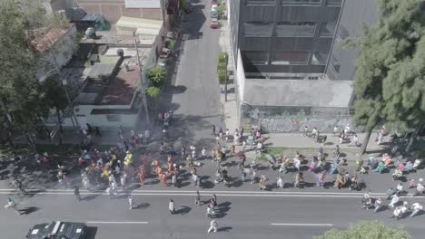 multitudes de personas diversas en trajes de carnaval marchando por las calles de la ciudad de méxico