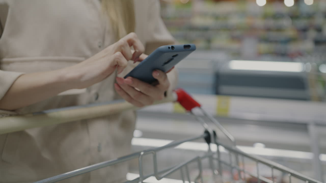 Woman using phone in grocery store