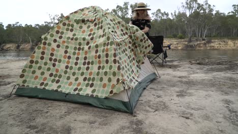 Blonde-woman-unzipping-tent-camping-in-Australia