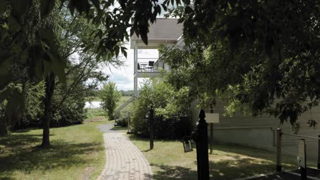 Wenn-Man-Hinter-Einem-Belaubten-Baum-Den-Gartenweg-Hinuntergeht,-Entdeckt-Man-Ein-Wunderschönes-Weißes-Haus-Auf-Dem-Grundstück-Des-Strathmere-Wedding-Centre-And-Spa