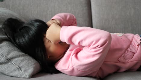 upset child lying on a sofa