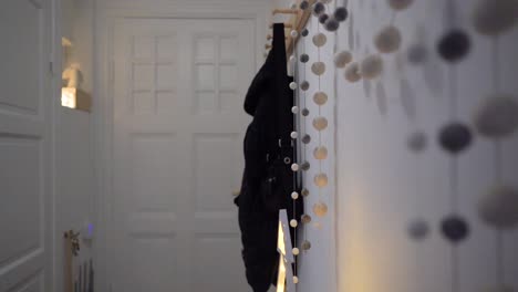 white minimal entryway with grey and white pom-pom garland hung from pegboard