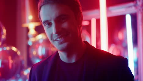 hot man raising glass at party. sexy guy staring at lens on neon background