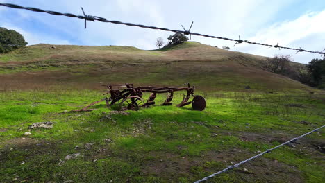 abandoned farm equipment on private land with barbed wire fencing