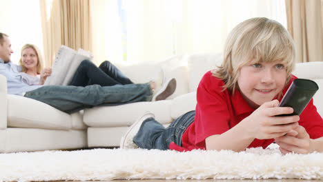 Niño-Viendo-Televisión-En-El-Suelo-Con-Sus-Padres-En-El-Sofá