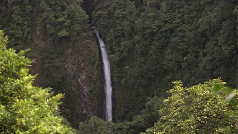 view of la fortuna waterfall with the cascade beautifully framed by the lush, green canopy of the surrounding jungle