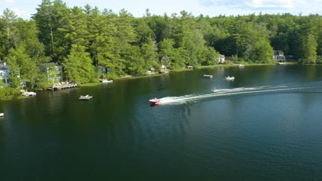 a woman in skis being pulled by a speedboat at a blue lake with splashes of water or waves can be observed