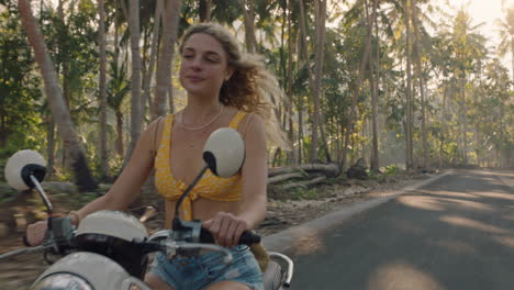 mujer feliz montando una motocicleta en un viaje por carretera a una isla tropical disfrutando de un paseo en motocicleta en vacaciones de viaje