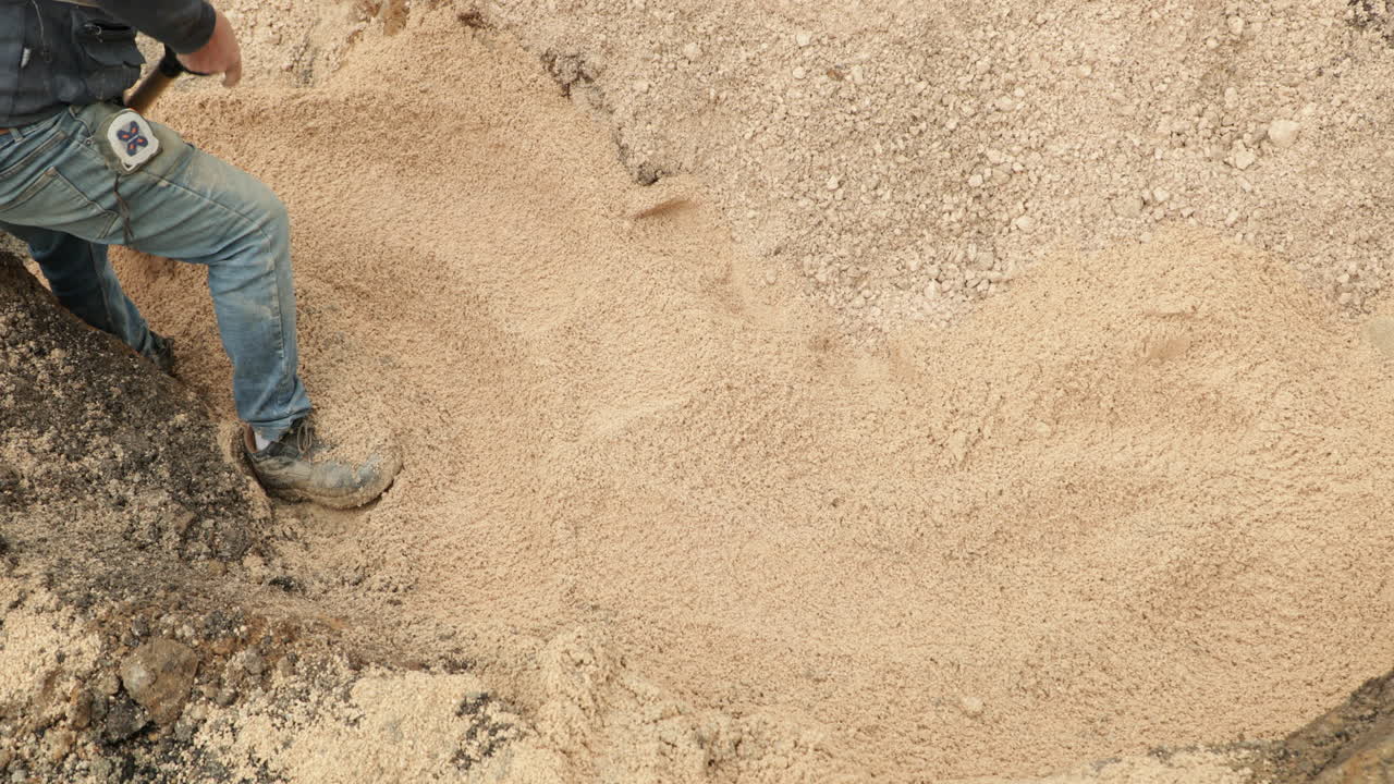 trabajador de la construcción palea el suelo para cubrir el tubo de pvc durante los trabajos de construcción en portugal