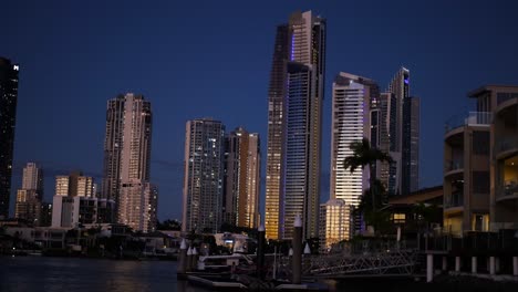 skyscrapers illuminated at night by the canal