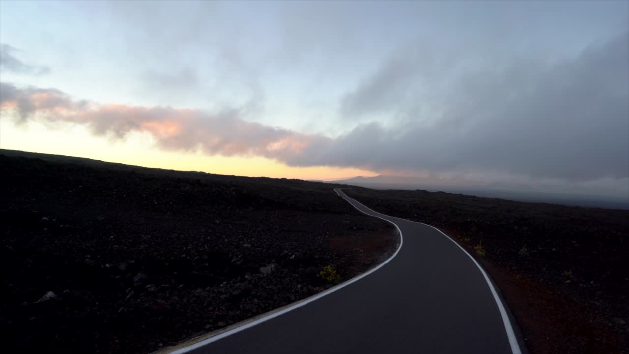 Minimalist Mauna Loa access road in lava fields after sunset towards Mauna Kea