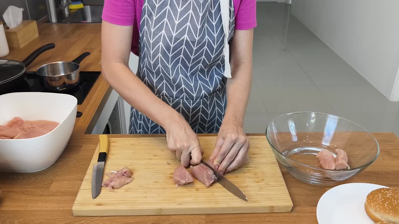 mujer preparando pollo crudo para hamburguesas