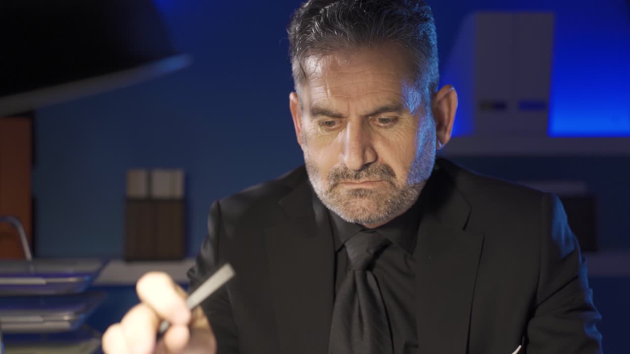 un hombre de negocios serio y centrado trabajando en una computadora portátil en la oficina nocturna.