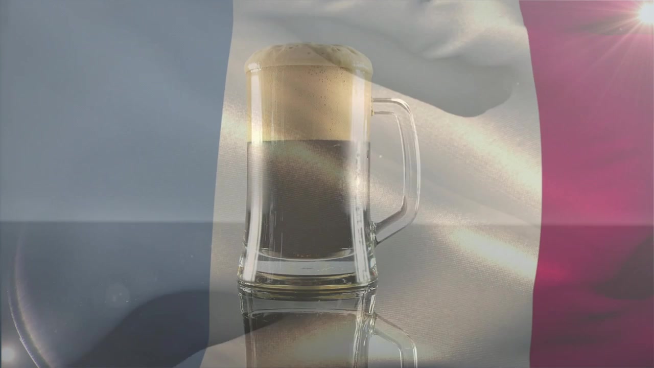Bandiera sventolante che avvia la chiarificazione di un boccale di vetro morbido, con schiuma che sale e bagliori di luce che scorrono, mettendo in mostra la birra.