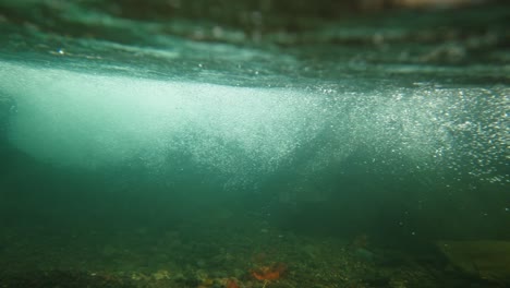 balinese reyong gamelan instrument captured underwater as it sinks into a river, creating dramatic bubbles and movement, blending traditional culture with artistic visual impact