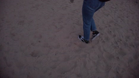 slow motion tracking shot of a girl walking on a sand beach