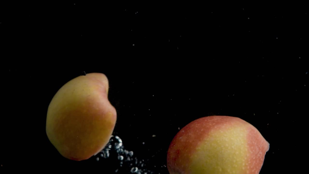 사과가 물에 빠지는 슈퍼 슬로모션, 검은색 배경, 많은 기포, 4k240fps