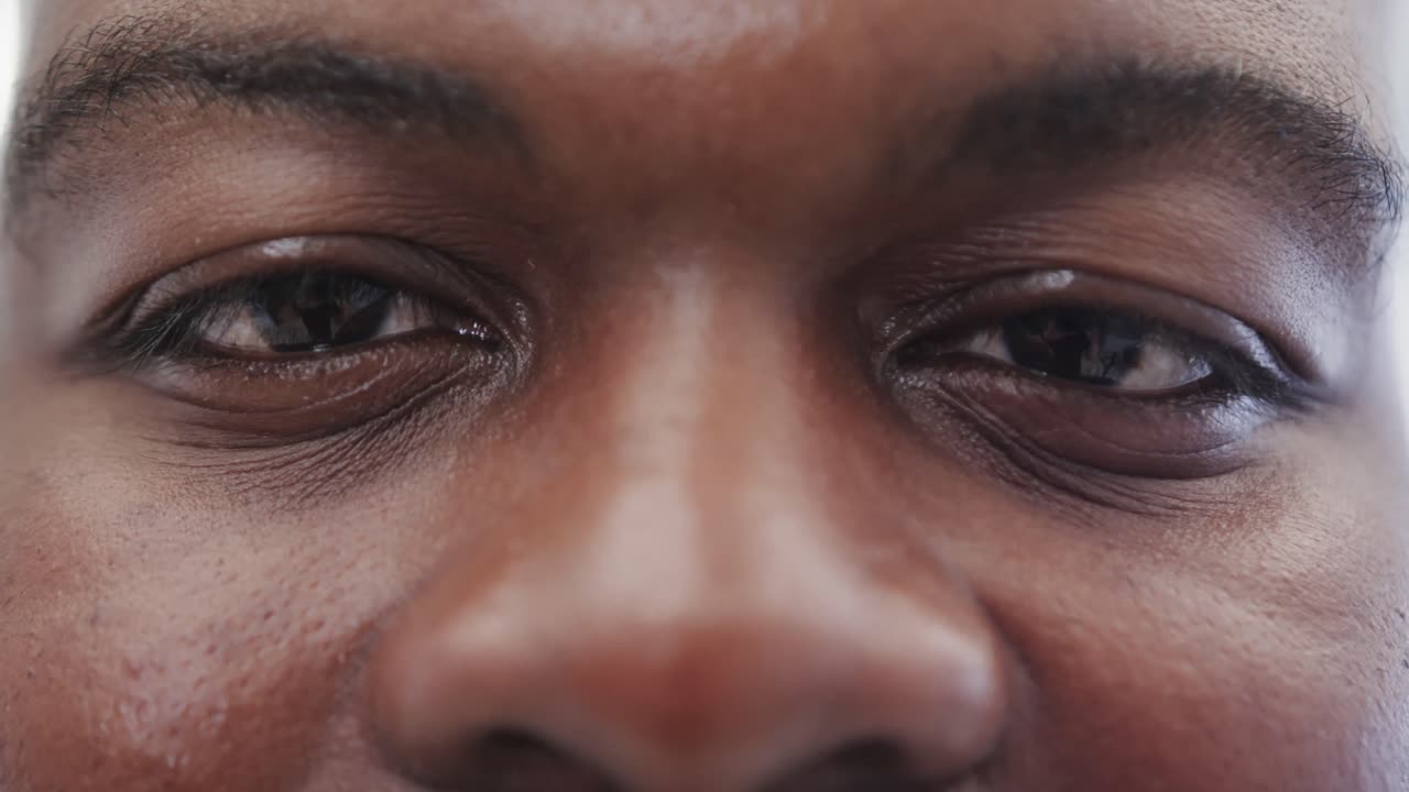 Close up of portrait of happy african american man looking at camera in slow motion