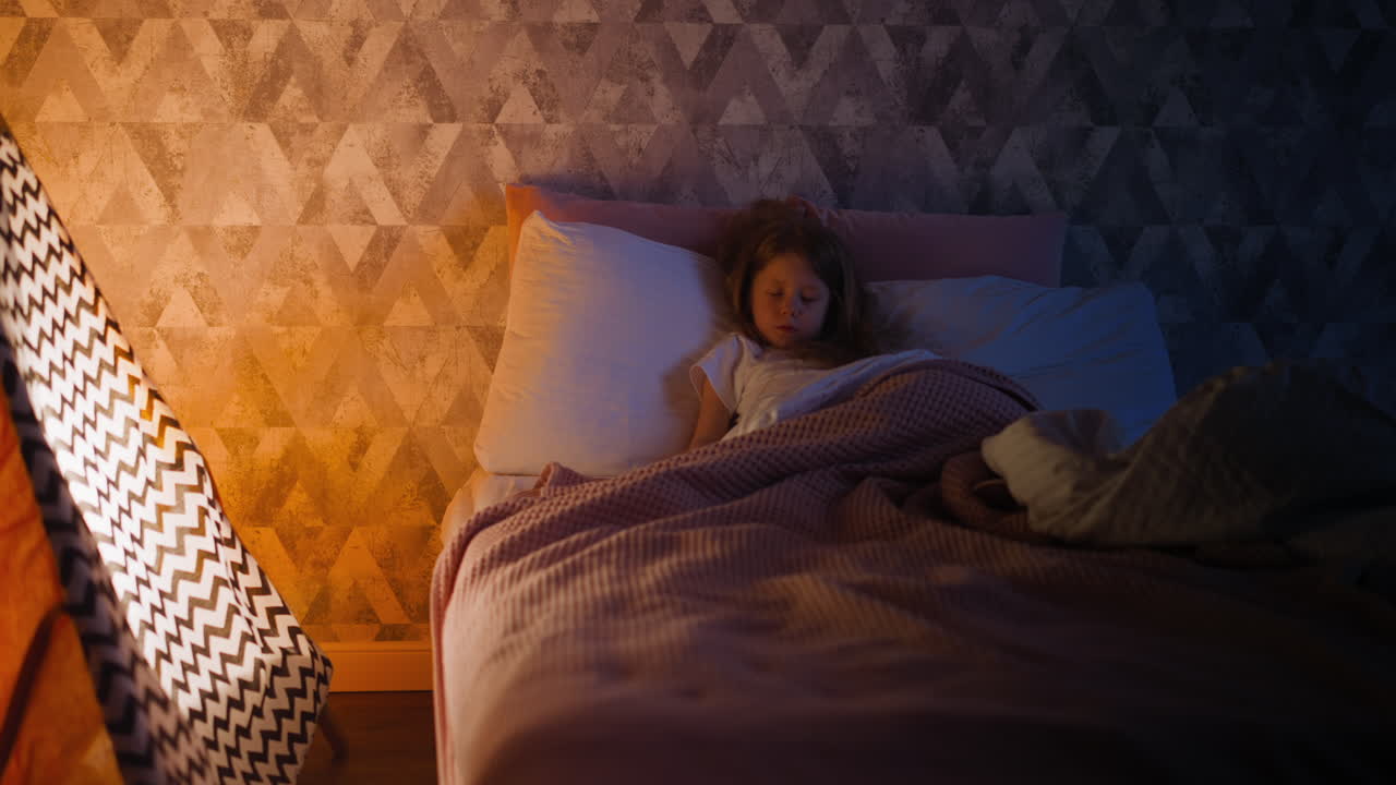 Little girl sleeps tight on bed by children teepee at home