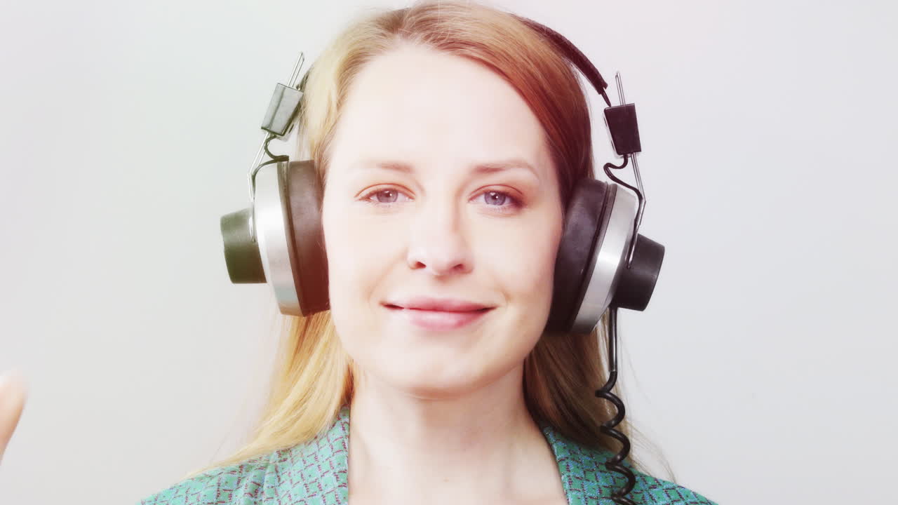 cool female dancer with changing retro headphones to listen to music