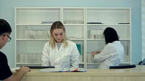 personal médico trabajando en torno al ocupado mostrador de recepción médica