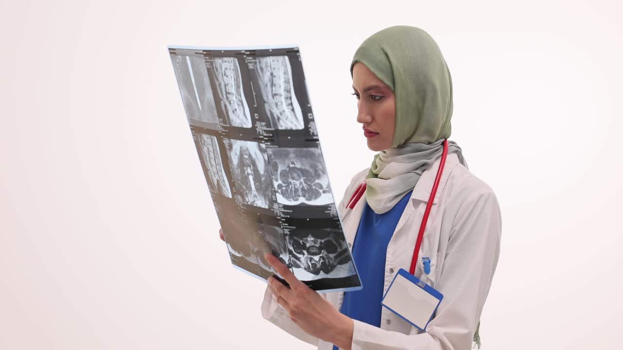 Female doctor in hijab examining medical scans