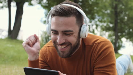man playing mobile game in park