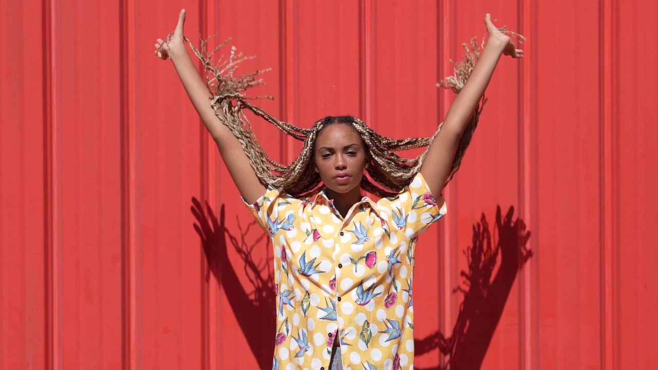 Black girl combed with colored braids letting them fall typical african hairstyle