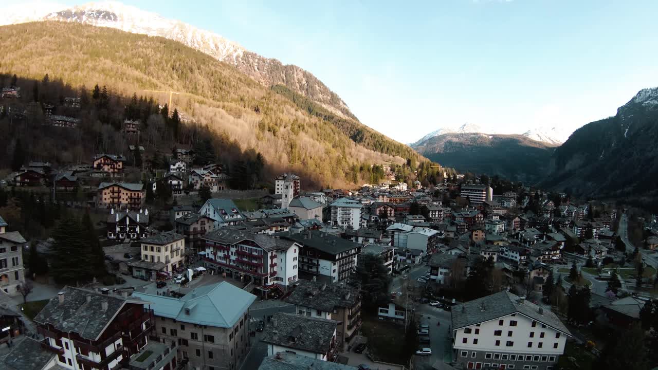 fpv drone aéreo sobre el centro turístico de montaña alpina y la iglesia de courmayeur, valle de aosta, italia, mont blanc monte bianco, volando sobre casas