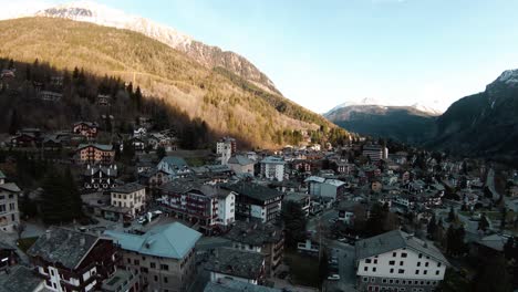 fpv drone aerial over alpine mountain resort centre and church of courmayeur, aosta valley, italy, mont blanc monte bianco, flying over houses