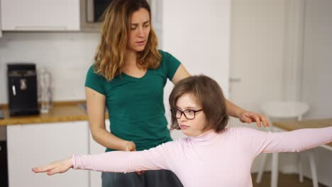 girl with down syndrome and her mom practicing yoga position at home