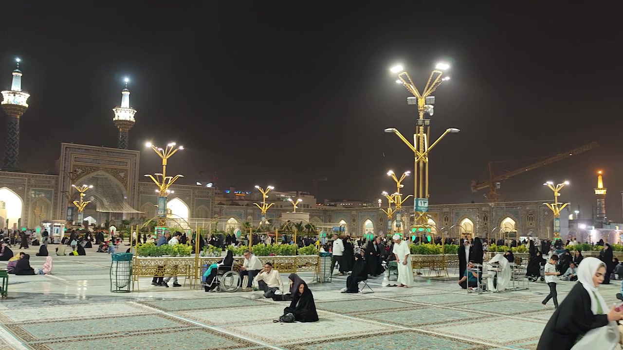 Folla che si raduna nel cortile del Santuario dell'Imam Reza di notte