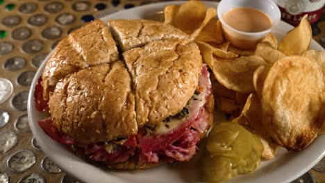 Traditional-cajun-style-muffuletta-sandwich-and-house-made-chips-with-remoulade-sauce,-slider-4K