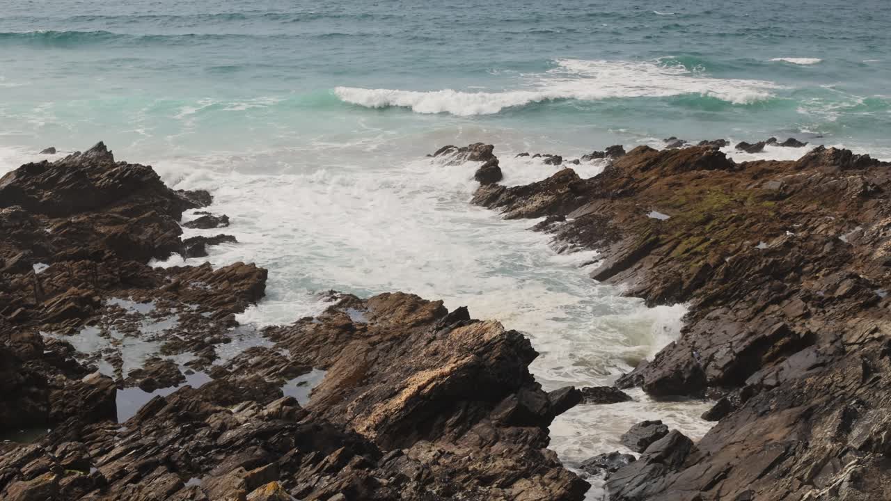 disparo estático de pequeñas olas que se estrellan contra una pequeña bahía rocosa en la playa fistral