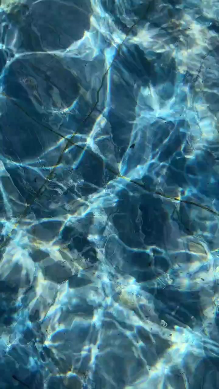 Acqua limpida e blu della piscina con riflessi scintillanti del sole