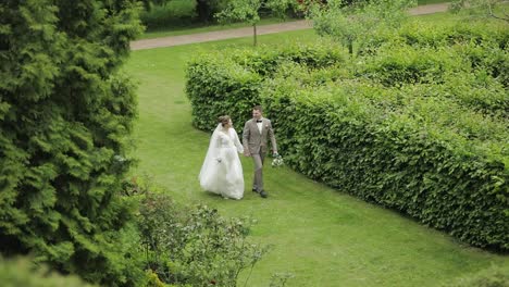 Recién-Casados.-Novio-Caucásico-Con-Novia-Caminando-En-El-Parque.-Pareja-De-Novios.-Hombre-Y-Mujer-Enamorados.