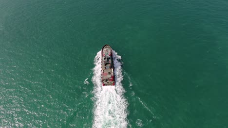 Small-Offshore-supply-ship-roaring-across-Hong-Kong-bay,-Aerial-view