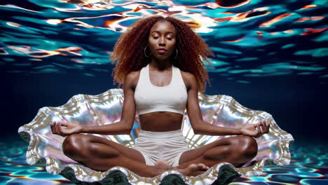 mujer meditando bajo el agua en una concha de perla