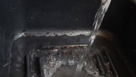 water from a tap filling a black coloured plastic bowl