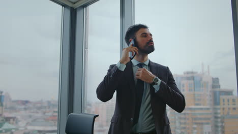 business man talking phone standing at office window close up. manager calling