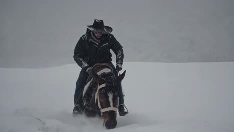 cowboy riding horse in snow