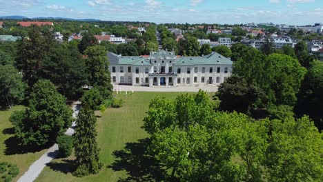 Edificio-Histórico-Al-Final-De-Un-Gran-Parque-Verde-En-Verano,-Toma-Aérea-De-Drones