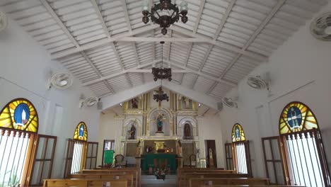 church of minca with ornate chandeliers and white wooden beams on the ceiling