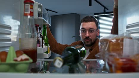 hombre buscando comida en el refrigerador