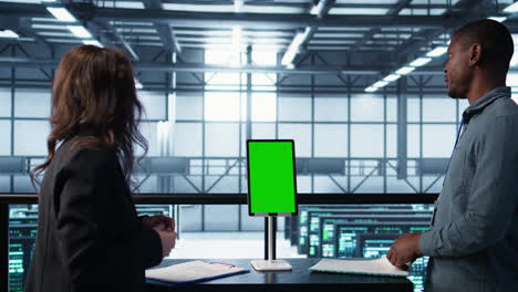 inspector comprobando documentos en el centro del servidor y utilizando la tableta de pantalla verde